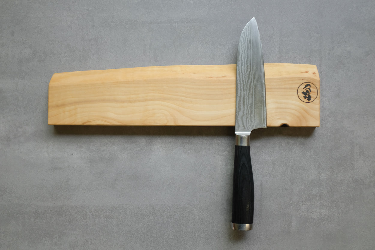 Messerhalter magnetisch in Vogelbeere, mit einem Santoku Messer rechts. Montiert an einer Wand.