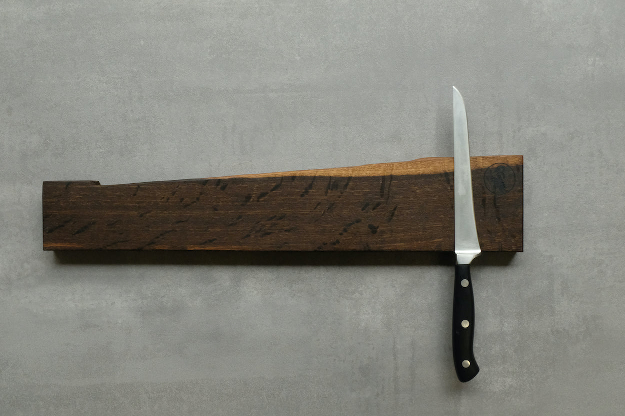 Räuchereiche Messerleiste mit einem Windmühlenmesser an einer Betonwand.