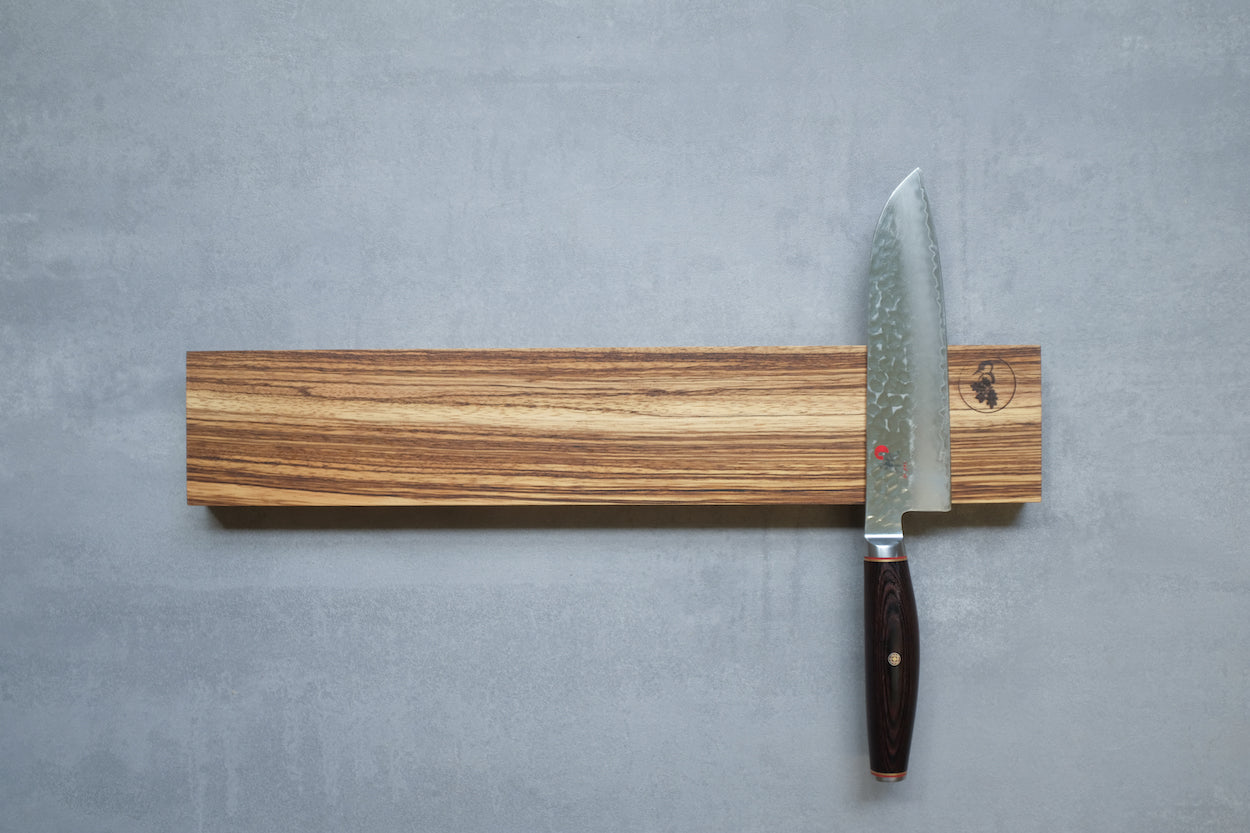 Zebrano Magnet Messerhalter mit einem Santos Messer an einer Betonwand befestigt