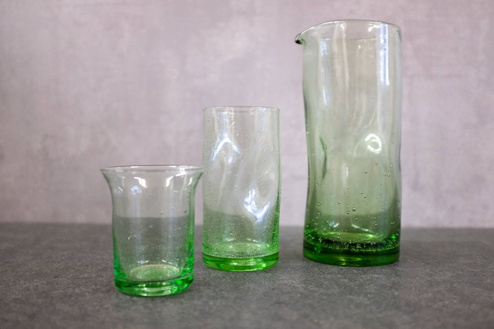 Trinkglas Goetheglas, Trinkbecher Handwerker und Karaffe mit Griffmulden aus grünem Waldglas. Gewinner Dineus 2020.