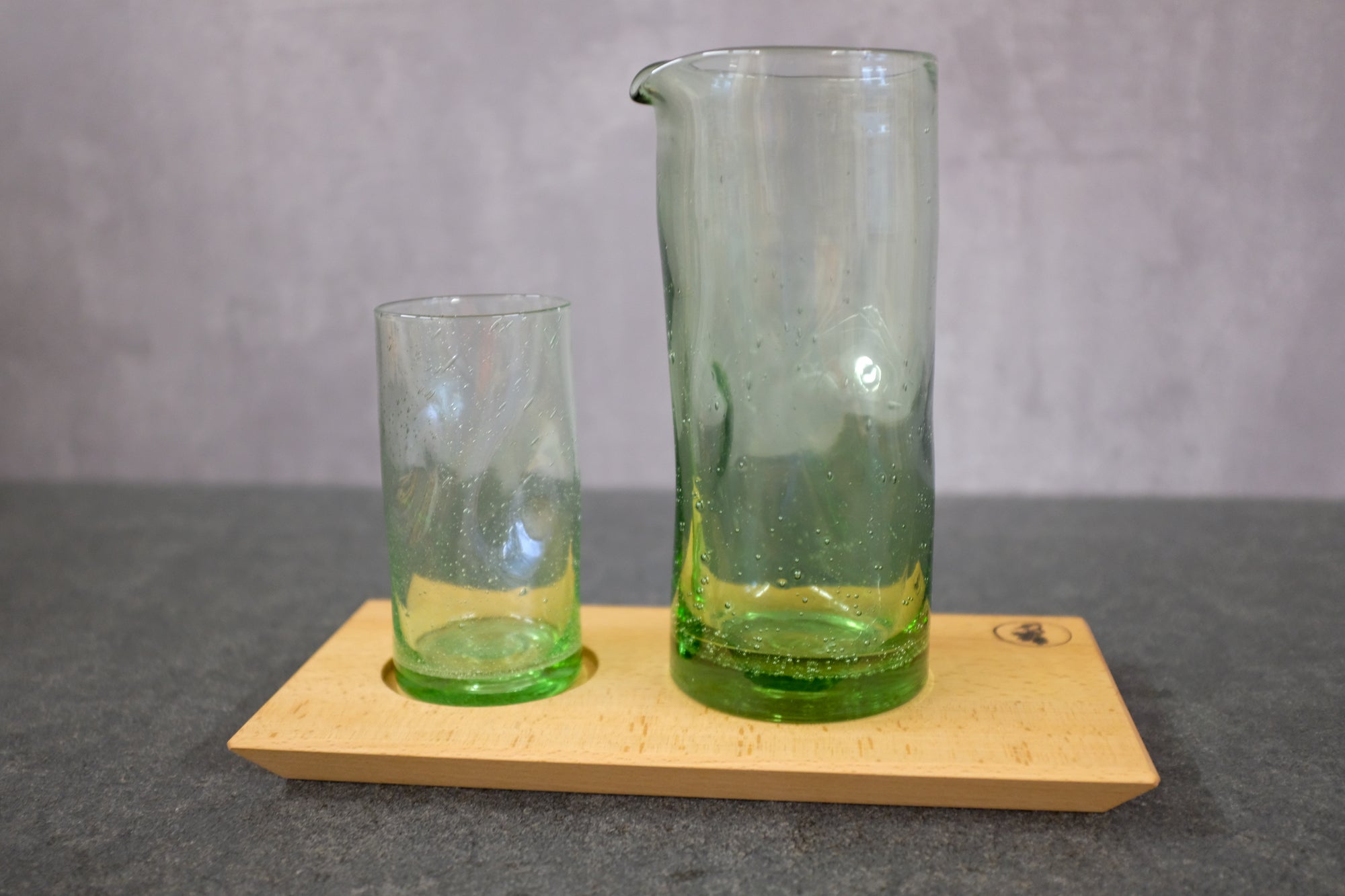 Handliches Trinkglas, 300 ml, und Wasserkrug, 1000 ml, auf einem Holztablett aus Buche massiv.